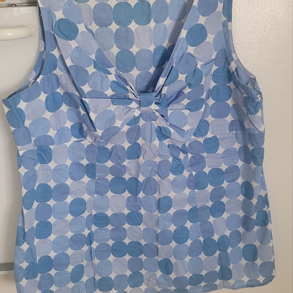 Cato top runs small, periwinkle poka dot top, fitted and with bow detail.